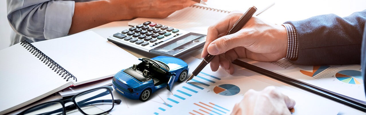 man pointing on graphs with blue car and calculator background